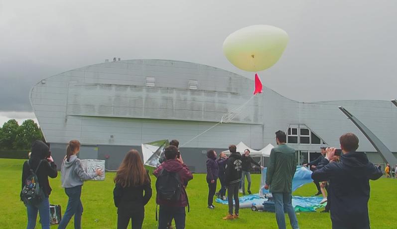 Le ballon prend son envol, sous un ciel menaçant